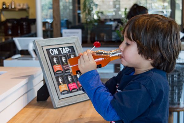 Young kombucha fan taking a sip at the kombucha mini bar located inside Ferm Farm. (Grant Geipel)