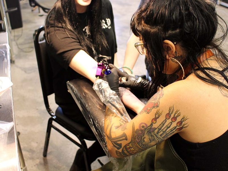 Sanchez tattooing a client using her left hand at Black Palm Tattoo. (Ashley Hern)